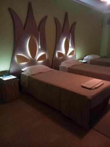 2 camas en una habitación con cabeceros omorficos en la pared en Hotel Vitoria, en Santarém