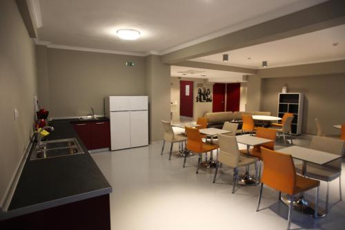 uma cozinha e sala de jantar com mesas e cadeiras em Stay Hybrid Hostel em Tessalônica