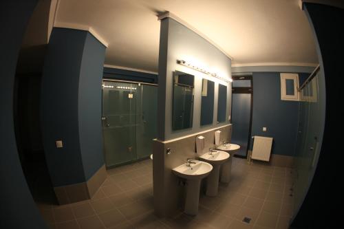 a bathroom with three sinks and three mirrors at Stay Hybrid Youth Hostel in Thessaloniki