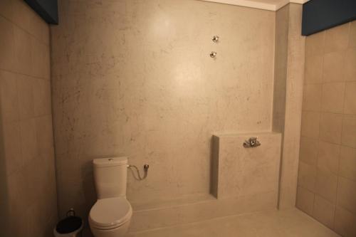 a bathroom with a toilet and a bath tub at Stay Hybrid Youth Hostel in Thessaloniki
