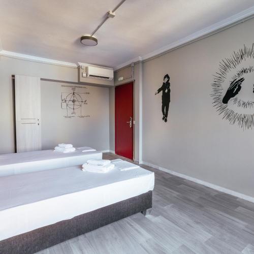 a room with two beds and a painting on the wall at Stay Hybrid Youth Hostel in Thessaloniki
