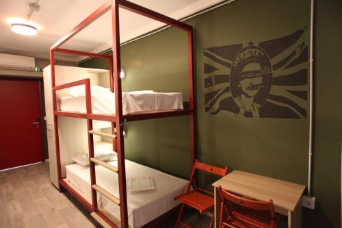 a room with bunk beds and a table and a table and chairs at Stay Hybrid Youth Hostel in Thessaloniki