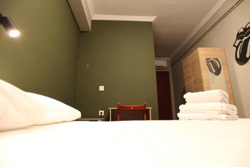 a room with a bed and a stack of towels at Stay Hybrid Youth Hostel in Thessaloniki