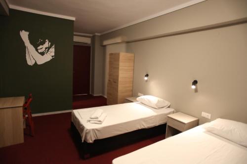 a hotel room with two beds and a mirror at Stay Hybrid Youth Hostel in Thessaloniki