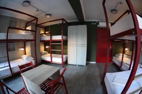 a room with bunk beds and a table and chairs at Stay Hybrid Youth Hostel in Thessaloniki