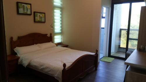 ein Schlafzimmer mit einem Bett und einem großen Fenster in der Unterkunft Kinmen 2 Home Puju Homestay in Jinhu