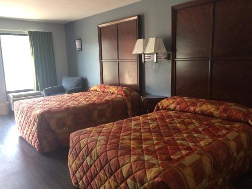 a hotel room with two beds and a window at Gulf American Inns in Decatur