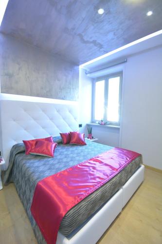 a bedroom with a large bed with red and purple pillows at Albergo Ardesio Da Giorgio in Ardesio