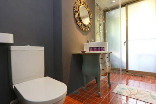 ein Badezimmer mit Toilette, Waschbecken und Spiegel in der Unterkunft Mood Story in Wujie