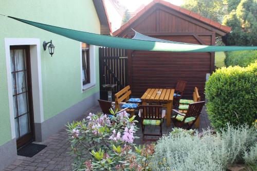 a patio with a table and chairs in a garden at Ferienwohnung "An der St. Ludmila" in Crostwitz