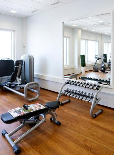 a gym with a row of exercise bikes and a mirror at Solo Sokos Hotel Paviljonki in Jyväskylä