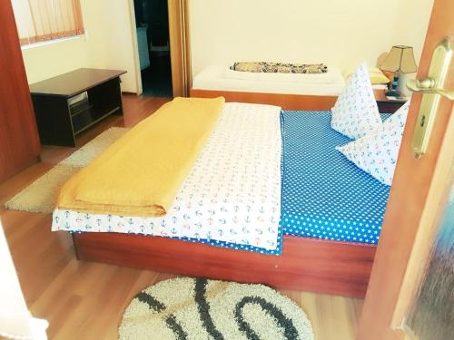 a bedroom with a bed with a blue and white comforter at Pensiunea Vasilescu in Horezu