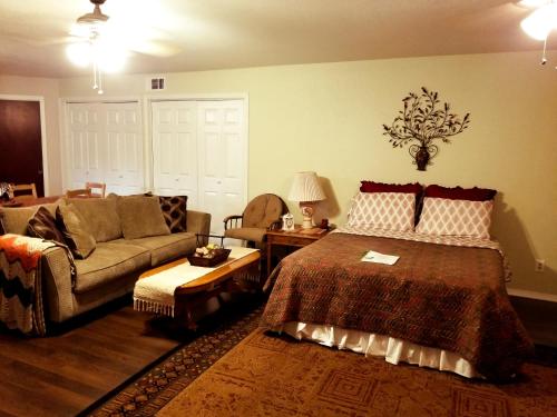 a living room with a bed and a couch at Charming Downstairs Unit in Oakhurst