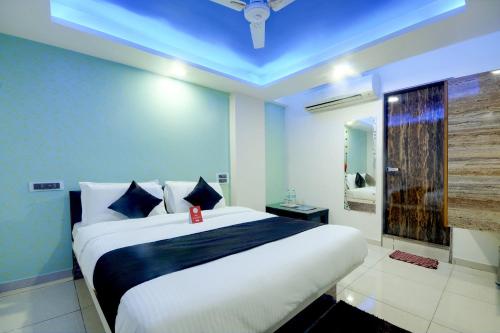 a bedroom with a large bed with a blue ceiling at Hotel Hillton in Gandhinagar