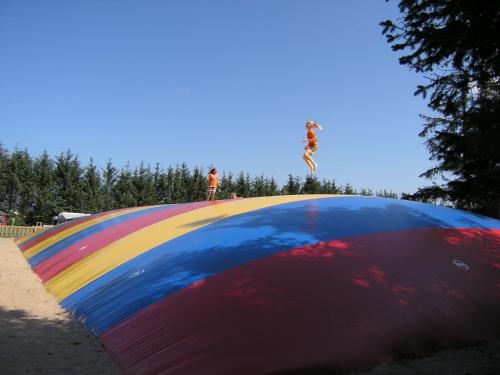 a person jumping over a colorful skateboard ramp at Løkken Klit Camping & Cottage Village in Løkken
