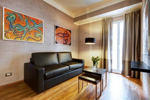 a living room with a black leather couch and a table at Dharma Luxury Hotel in Rome