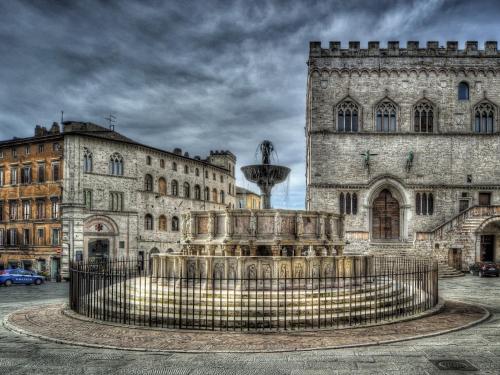 a fountain in front of an old building at Residenze L'Uncinaia Holiday House in Perugia