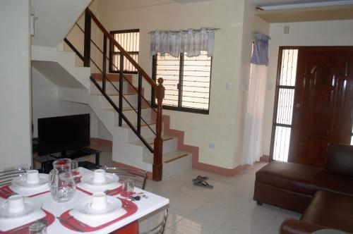 a living room with a staircase and a couch at Manora Apartment in Talisay