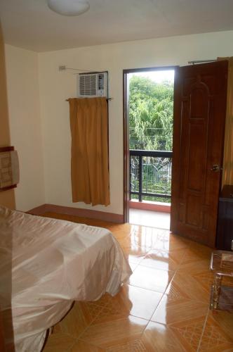 a bedroom with a bed and a sliding glass door at Manora Apartment in Talisay