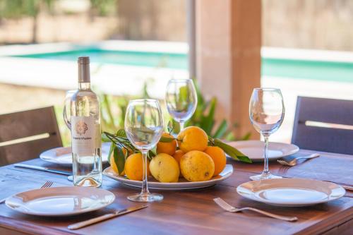 a table with a plate of oranges and wine glasses at Can Moscari in Inca