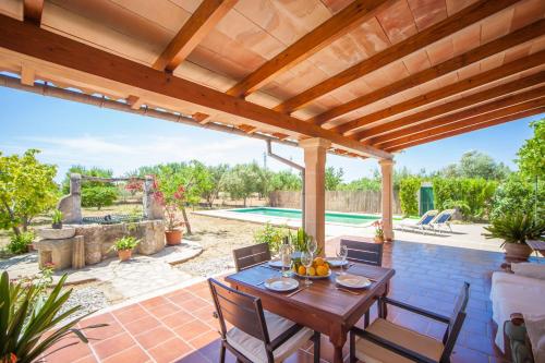 a patio with a table and chairs under a wooden pergola at Can Moscari in Inca