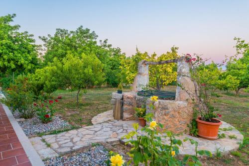 a stone fountain in a garden with flowers at Can Moscari in Inca