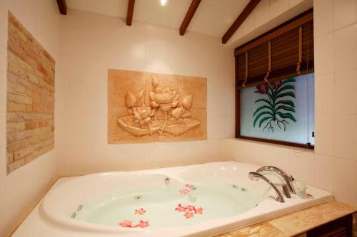 a bathroom with a tub with a painting on the wall at Villa Suriya B2 in Patong Beach