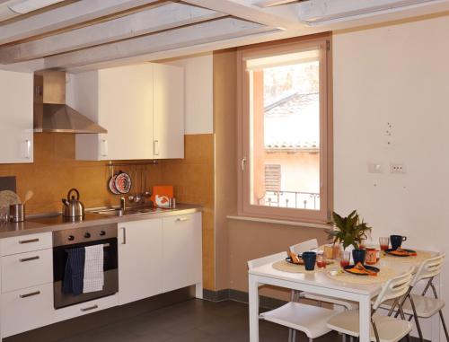 a kitchen with white cabinets and a table and a window at Niki O. Apartments in Parma