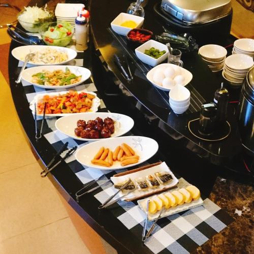 a buffet with plates of food on a table at Hotel Satellite in Satsumasendai