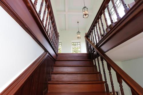 a wooden staircase with wooden railings in a house at Baan 2459 Heritage House in Bangkok