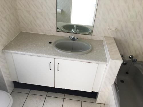 y baño con lavabo y espejo. en Dumela Margate Flat No 18, en Margate