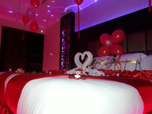 a red and white bed with a heart decoration on it at Park Jizan Hotel in Jazan