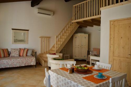 a living room with a table and a staircase at Corte Attilea in Valeggio sul Mincio