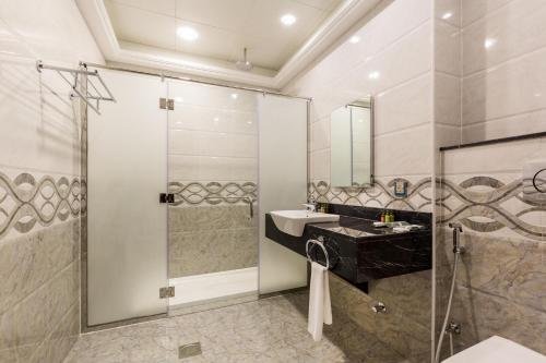 a bathroom with a sink and a shower at Palma Beach Resort & Spa in Umm Al Quwain