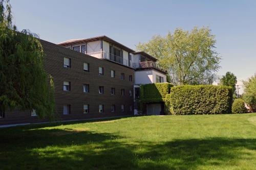 ein Gebäude mit einem Rasenplatz davor in der Unterkunft SeeHotel & Restaurant die Ente in Schwetzingen