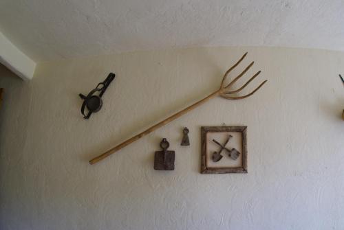 a clock hanging on a wall with tools on it at La Casa de la Abuela in Cazorla