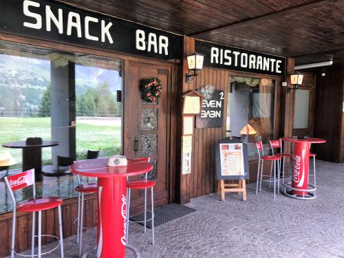 a restaurant with red stools in front of a bar at I Dadi Cielo Alto cir VDA Valtournenche 0446 in Breuil-Cervinia