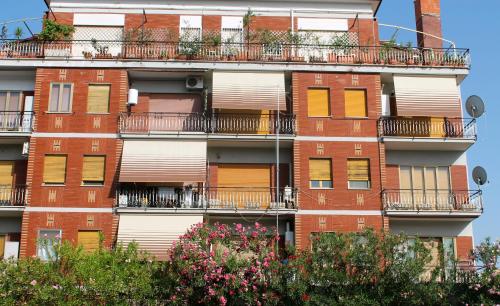 um edifício de apartamentos com varandas e árvores em Aurelio Commodo Apartment em Roma