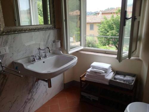 a bathroom with a sink and a window and towels at Relais Villa Poschi in Pugnano