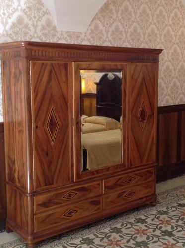 a wooden dresser with a mirror in a bedroom at B&B Lauretum in Loreto Aprutino