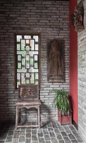a bench sitting in front of a wall with a window at Yangshuo Village Inn Boutique Hotel in Yangshuo