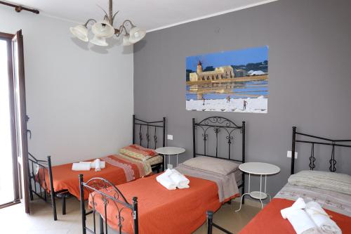 una camera con tre letti e un dipinto sul muro di Conte Agostino Pepoli a Trapani