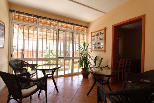 a room with tables and chairs and a large window at Kira's Boutique Hotel in Mindelo