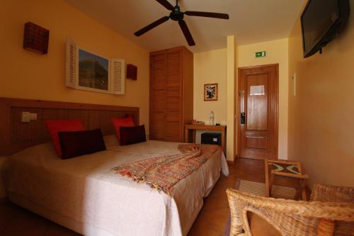 a bedroom with a bed and a ceiling fan at Kira's Boutique Hotel in Mindelo