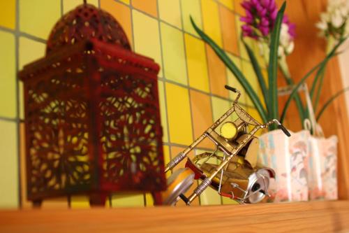 a shelf with a vase of flowers and a candle at Kira's Boutique Hotel in Mindelo