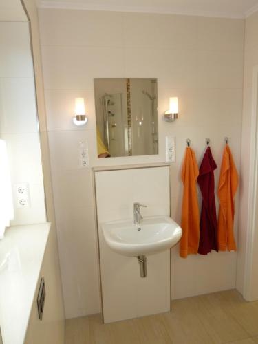 W łazience znajduje się umywalka i lustro. w obiekcie Ferienhaus Kugelbake w mieście Cuxhaven