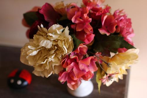 a white vase filled with colorful flowers on a table at Kira's Boutique Hotel in Mindelo