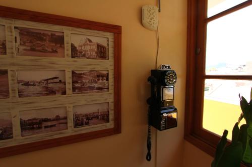a phone hanging on a wall next to a window at Kira's Boutique Hotel in Mindelo