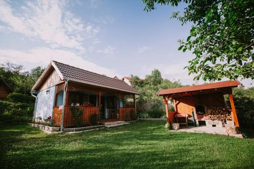 a small house with a porch and a shed at Bosnyák Panzió in Odorheiu Secuiesc