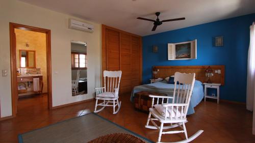 a bedroom with a bed and two chairs at Kira's Boutique Hotel in Mindelo